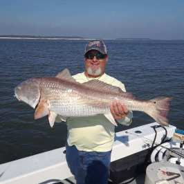 a person holding a fish on a boat in the water