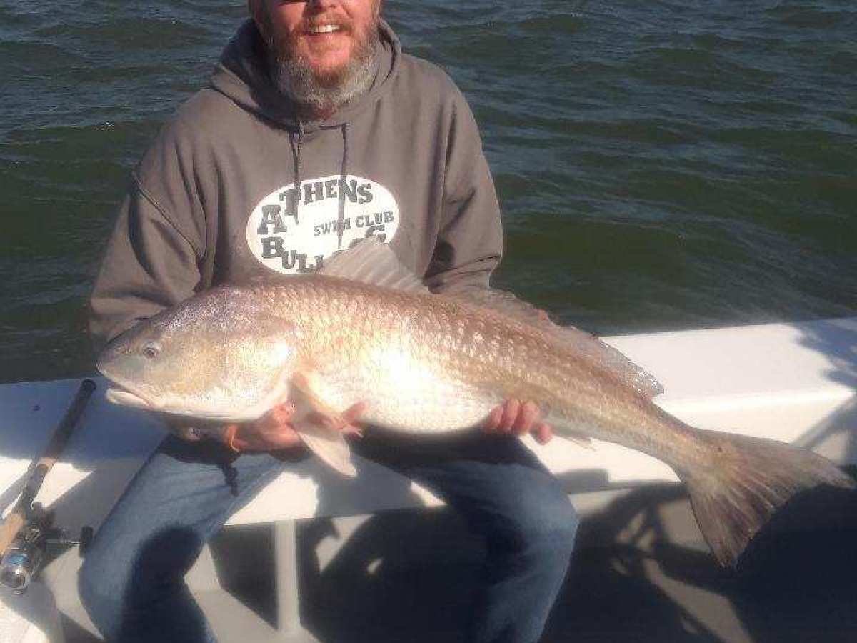 a man holding a fish in the water