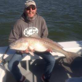 a man holding a fish in the water