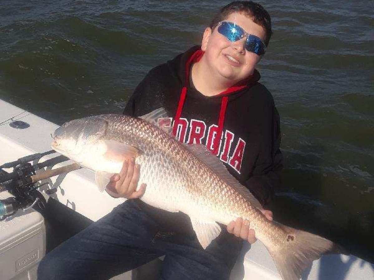 a man holding a fish in the water