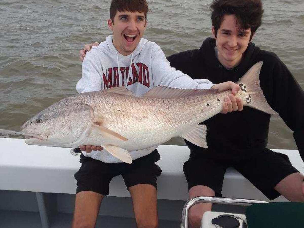 Joshua Moore holding a fish in the water