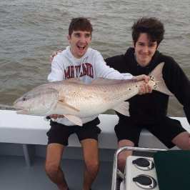Joshua Moore holding a fish in the water