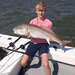 a person holding a fish on a boat in the water