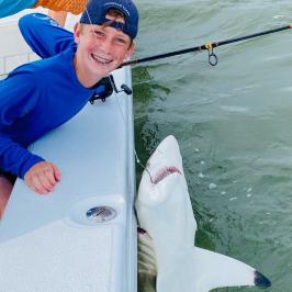 a person holding a fish in the water