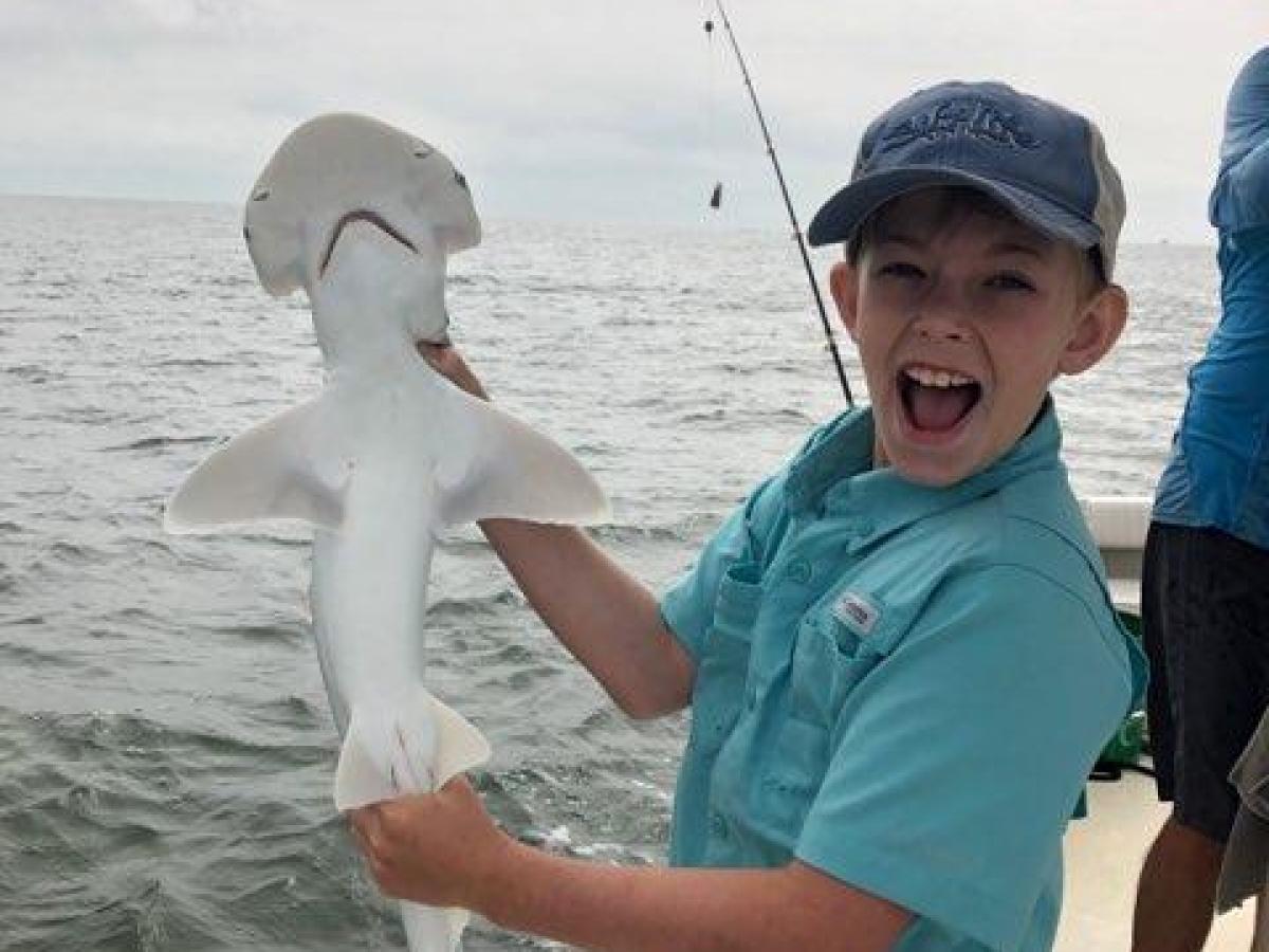 a person holding a fish in the water