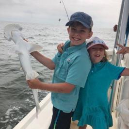 a person holding a fish on a boat in the water