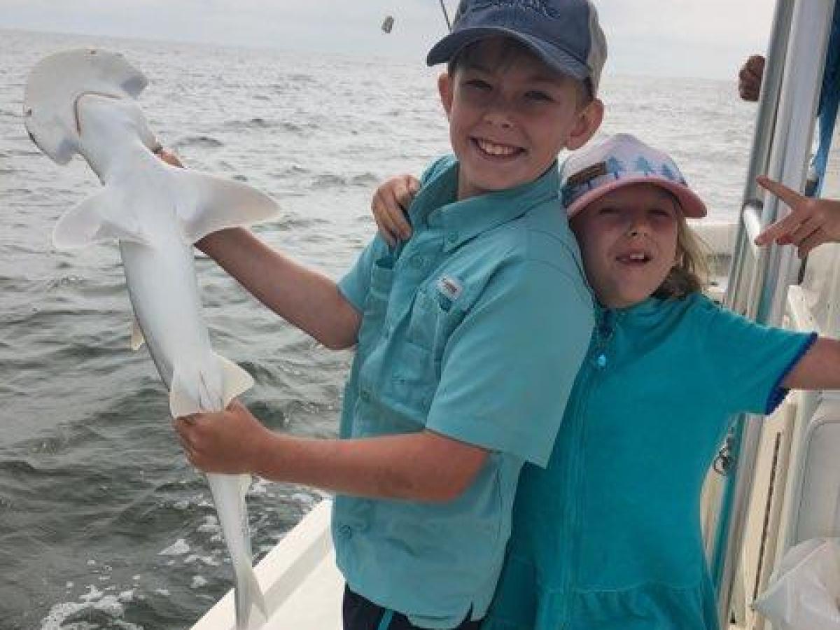 a person holding a fish on a boat in the water