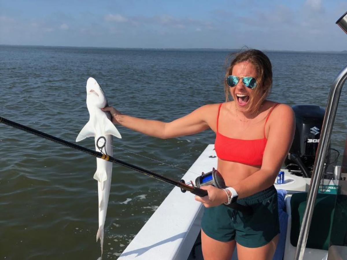 a woman standing next to a body of water