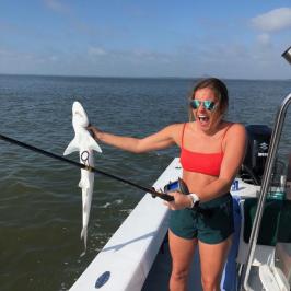 a woman standing next to a body of water