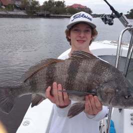 a person holding a fish on a boat in the water