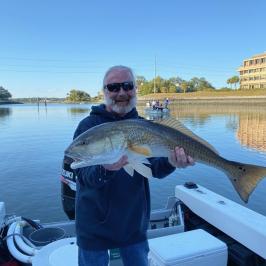a person holding a fish on a boat in a body of water