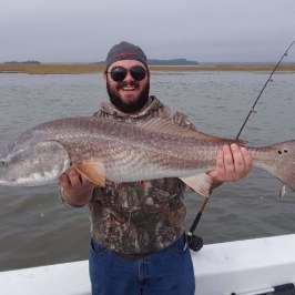 a man holding a fish in the water