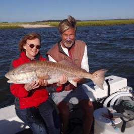 a person holding a fish in the water