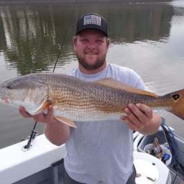 a man holding a fish in the water