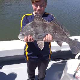 a man standing next to a body of water
