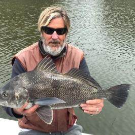 a man holding a fish swimming under water