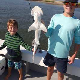 a boy standing next to a body of water