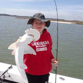 a person holding a kite in a boat on a body of water