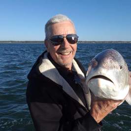 a man holding a fish in the water
