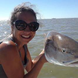 a person holding a fish in the water