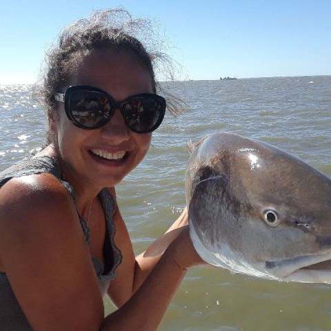 a person holding a fish in the water