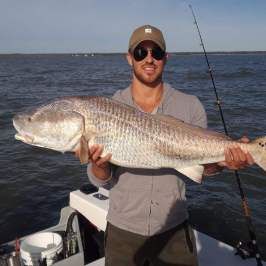 a man holding a fish in the water