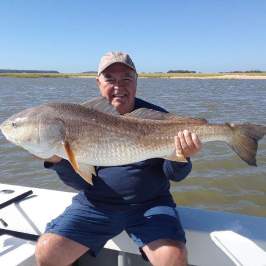 a man holding a fish in the water