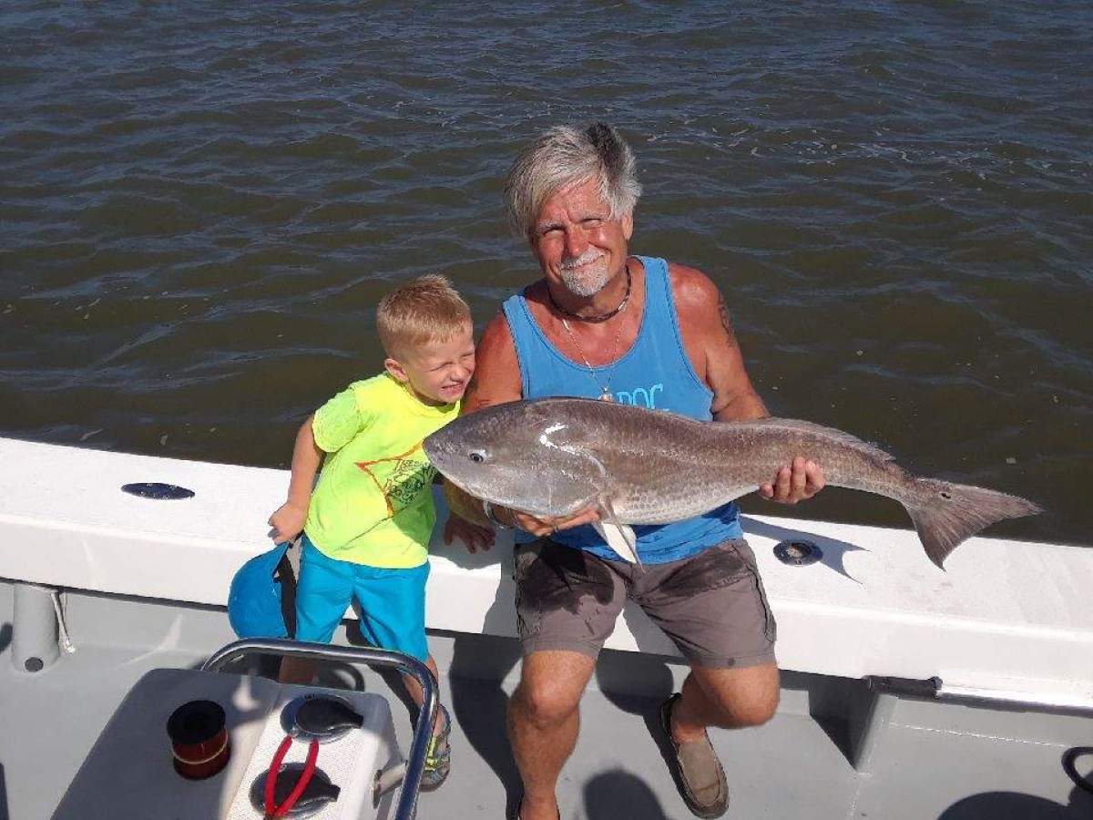 a man holding a fish swimming under water