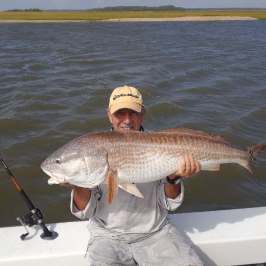 a person holding a fish on a boat in a body of water