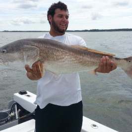 a man holding a fish in the water