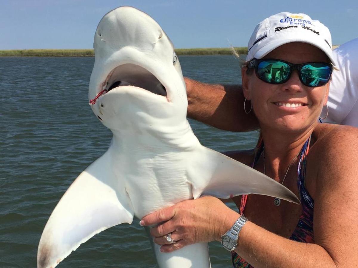 a person holding a fish in the water