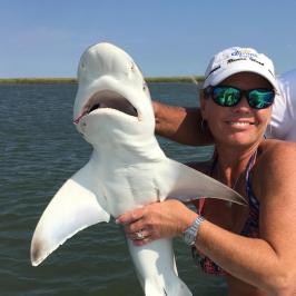 a person holding a fish in the water