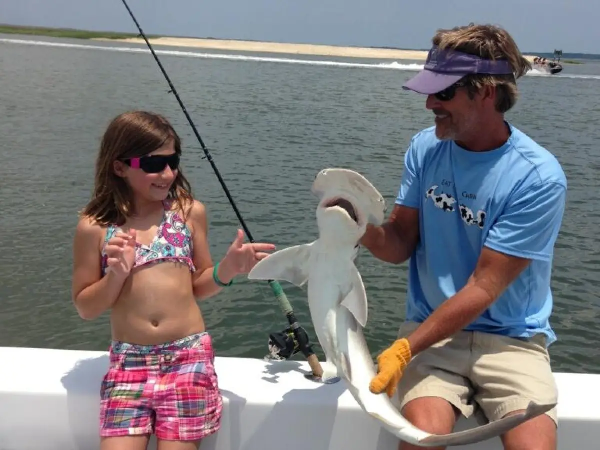 a group of people standing next to a body of water