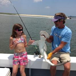 a group of people standing next to a body of water